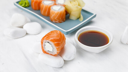 Japanese cuisine. Philadelphia roll with salmon on a white table. 


