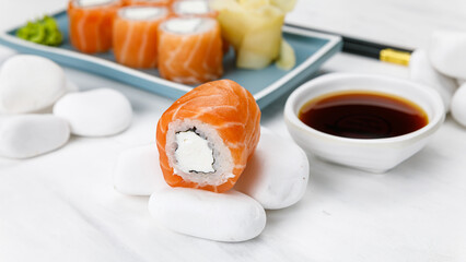 Japanese cuisine. Philadelphia roll with salmon on a white table. 

