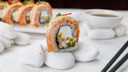 Japanese cuisine. Philadelphia roll with salmon on a white table. 

