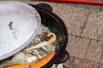 the cauldron in which the Ear is cooked. Carrots, fish and onions are visible