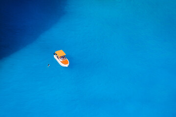 Fototapeta na wymiar A boat in the lagoon. View of the sea bay and a lone boat from a drone. Blue sea water. Vacation and travel. Summer landscape from the air.