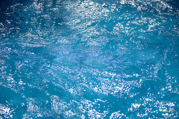 Fototapeta premium sparkling water surface in the pool in the sun, summer minimalistic calm background with copyspace. 