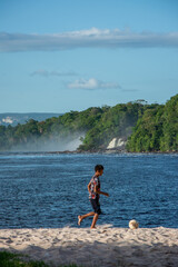 Fototapeta na wymiar Indigenous children playing soccer on the shore of the Canaima lagoon