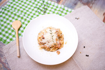 a portion of risotto with seafood and parmesan cheese grated on top. one plate on the table top view.