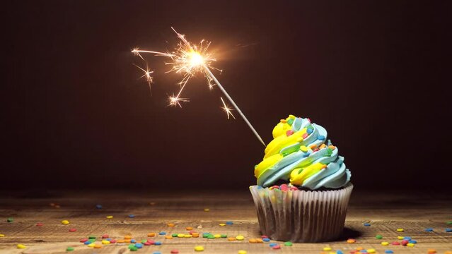 Delicious cupcake with blue-yellow cream icing. sweet dessert with sparkler