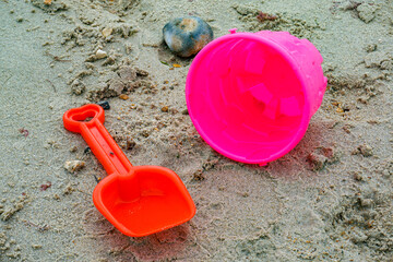 Fototapeta na wymiar children's bucket and spade on sand at beach. School holiday concept. Beside the seaside 