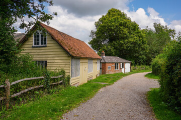 Fototapeta na wymiar countryside lane with rustic barns. farmyard barn buildings in peaceful rural setting