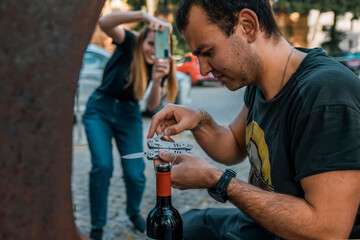 A man tries to take a cork out of a bottle without a corkscrew