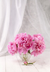 Bouquet of pink peonies in a vase on a wooden table. Gift Valentine's Day