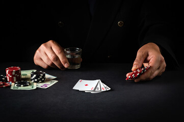 Playing poker in the club. A player bets on a winning combination with playing cards four of a kind...
