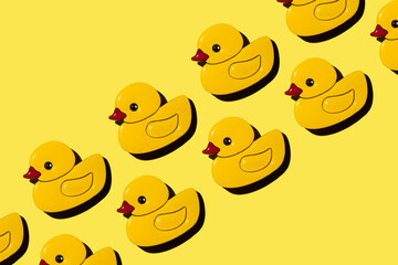 many figures of a duckling on a yellow background