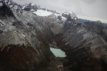 the photo captures the moment of takeoff and flight by plane over Ushuaia — a city and port in...