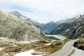 Fototapeta na wymiar A picture of mountain, dam and road at Grimsel Pass. The Grimsel Pass links the Hasli Valley in the Bernese Oberland with Goms in Valais.