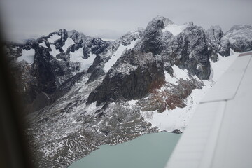 the photo captures the moment of takeoff and flight by plane over Ushuaia — a city and port in...