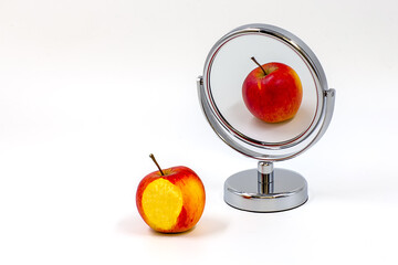 Apple and its reflection in a mirror on white background. Different reflection. White space for text.