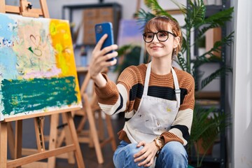 Young woman artist make selfie by the smartphone at art studio