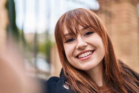 Young woman smiling confident making selfie by the camera at street