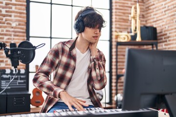 Fototapeta na wymiar Young hispanic man musician composing song at music studio
