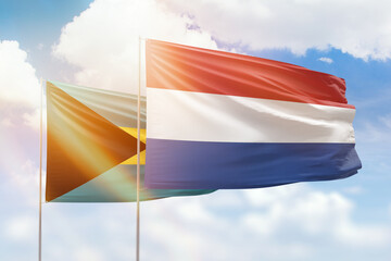 Sunny blue sky and flags of netherlands and bahamas