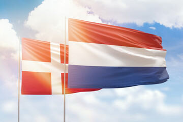 Sunny blue sky and flags of netherlands and denmark