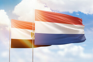 Sunny blue sky and flags of netherlands and egypt