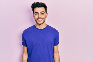 Obraz premium Young hispanic man wearing casual t shirt with a happy and cool smile on face. lucky person.