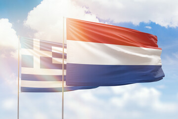 Sunny blue sky and flags of netherlands and greece