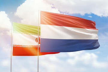 Sunny blue sky and flags of netherlands and iran