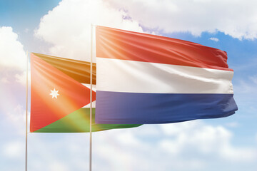 Sunny blue sky and flags of netherlands and jordan