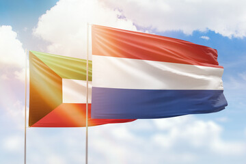 Sunny blue sky and flags of netherlands and kuwait