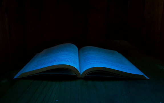 Libro abierto en la oscuridad, libro de hechizos, libro de magia, libro de artes oscuras