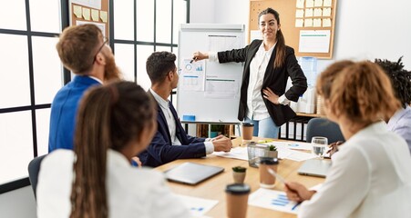 Obraz premium Group of business workers listening hispanic boss woman conference at the office.