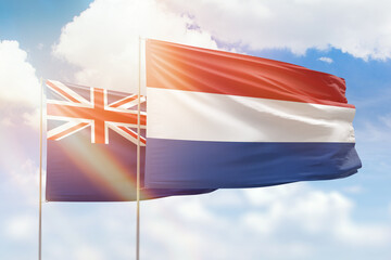 Sunny blue sky and flags of netherlands and new zealand