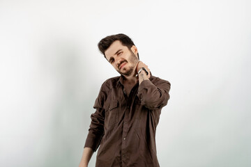 Fototapeta premium Caucasian young man wearing shirt posing isolated over white background feels physical discomfort unhealthy tired closed his eyes for neck pain. Shoulder ache concept.