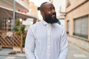 Naklejka premium Young african american man smiling confident standing at street