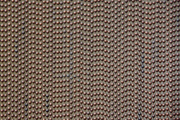 Close-up view of a copper colored curtain made of stringed metal beads