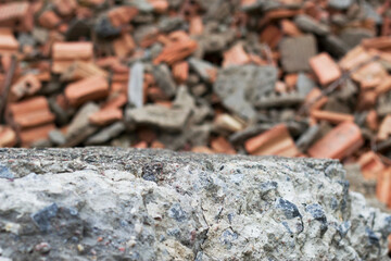 grey concrete stone with brocken red bricks on the background as a ruins of building backdrop