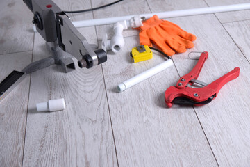 soldering iron for welding polypropylene pipes, scissors, pipes and gloves, top view