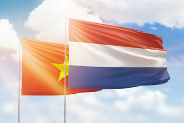 Sunny blue sky and flags of netherlands and vietnam