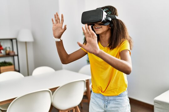 African american girl playing video game using vr glasses at home