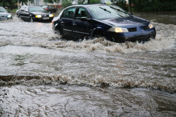 Car traffic at flooded street on heavy rain.