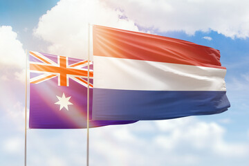 Sunny blue sky and flags of netherlands and australia