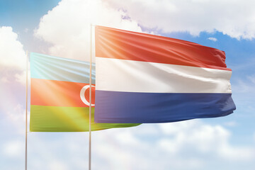 Sunny blue sky and flags of netherlands and azerbaijan