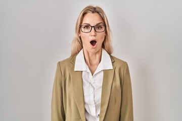 Young caucasian woman wearing glasses scared and amazed with open mouth for surprise, disbelief face