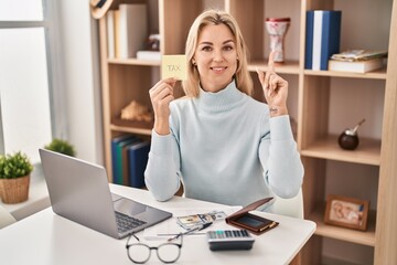 Young caucasian woman calculating money savings surprised with an idea or question pointing finger with happy face, number one