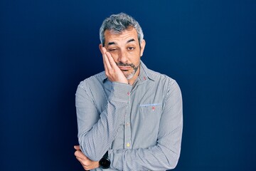Fototapeta premium Handsome middle age man with grey hair wearing business shirt thinking looking tired and bored with depression problems with crossed arms.
