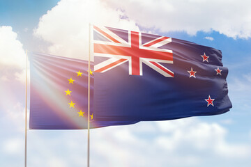 Sunny blue sky and flags of new zealand and european union