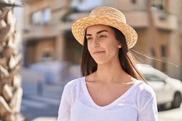 Young hispanic woman tourist smiling confident standing at street