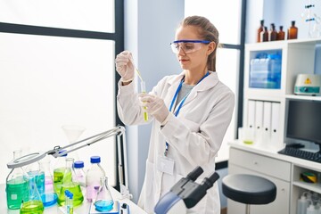 Young blonde woman wearing scientist uniform working at laboratory