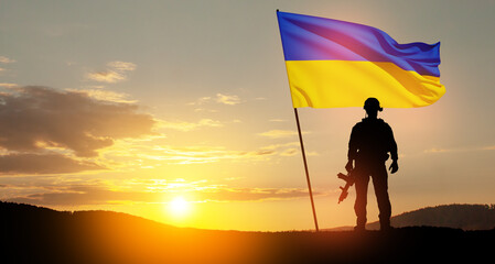 Flag of Ukraine with silhouette of soldier against the sunrise or sunset. Concept - armed forces of...